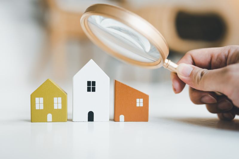 Magnifying glass and house model, house selection, real estate concept